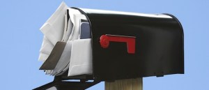 Black Mailbox stuffed with junk mail on a blue background